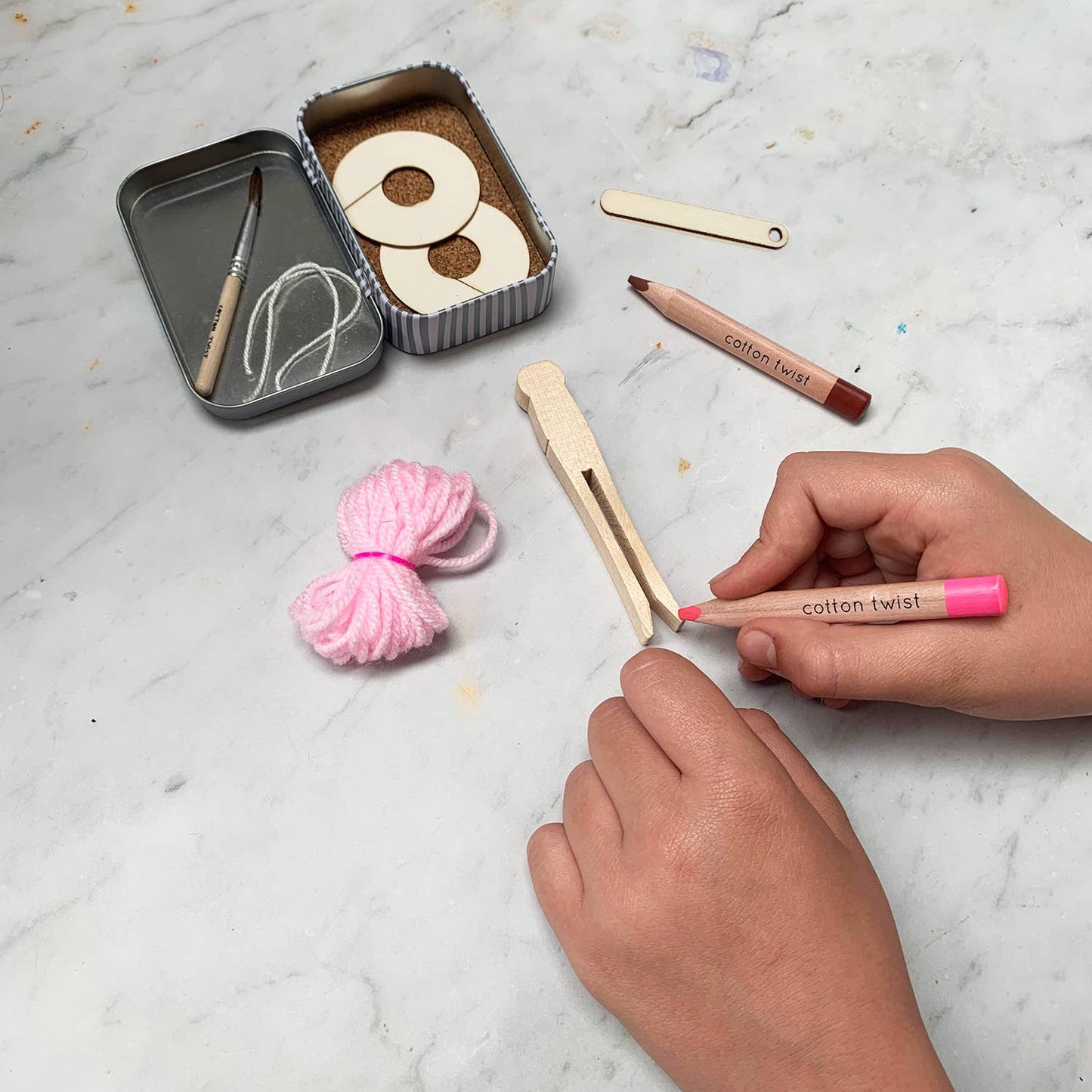 DIY Ballerina Craft Kit with wooden pieces, pink yarn, and tools in a keepsake tin.