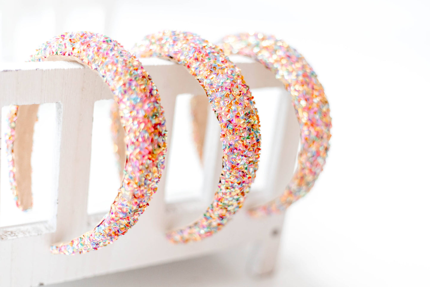 A beaded headband with sparkling pink crystals, featuring a colorful, glittery design.
