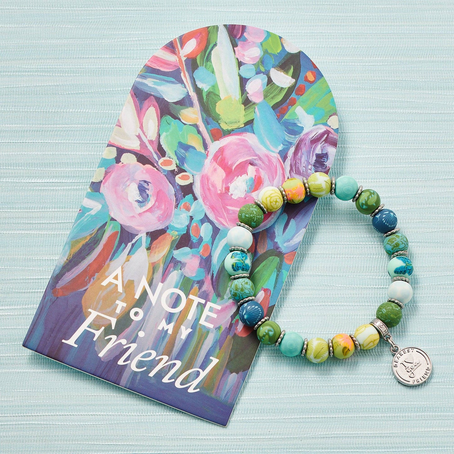 Multicolor beaded friendship bracelet with a round charm, perfect for gifting to friends.