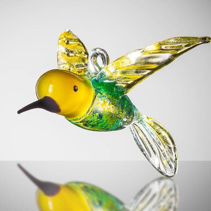 Yellow and blue glass hummingbird with green accents and outstretched wings