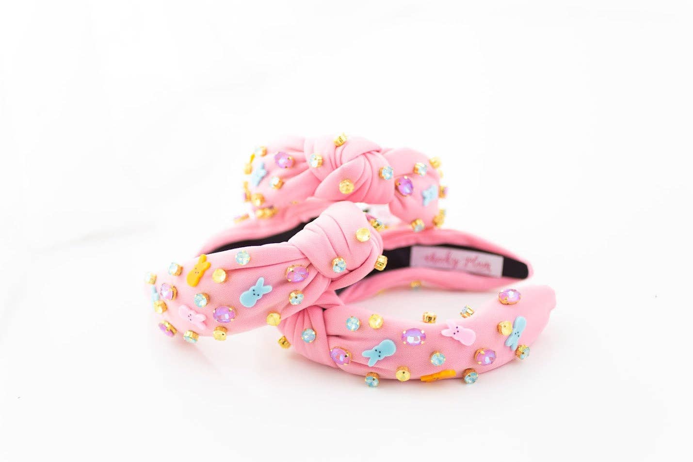Pink headband adorned with pastel bunny peep charms and colorful gemstones in yellow, blue, and purple.