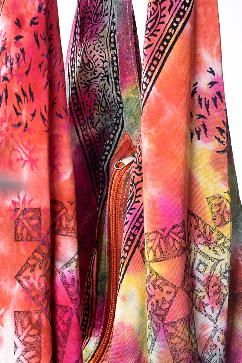 A vibrant tie-dye and block-printed boho shoulder bag with a unique orange zipper.