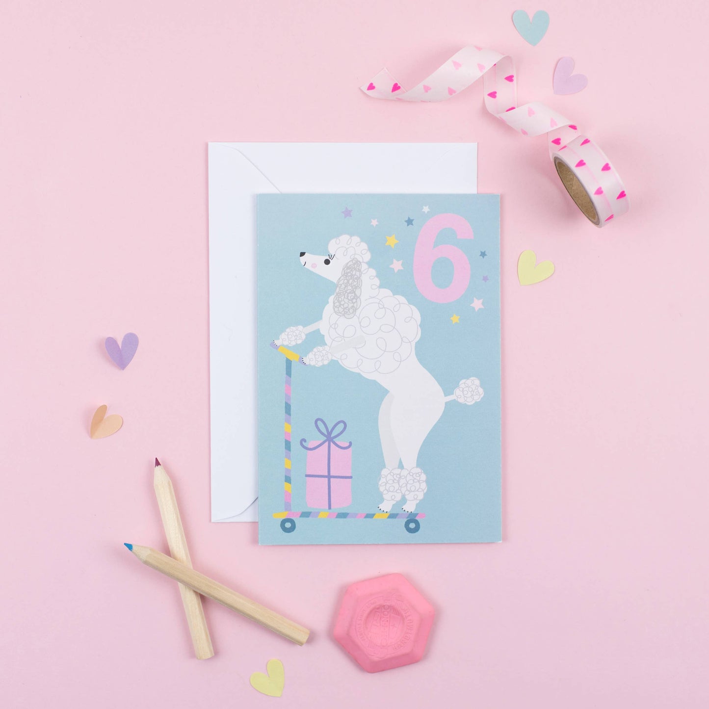 A blue birthday card featuring a cute poodle on a scooter with a big number 6 and a gift box.