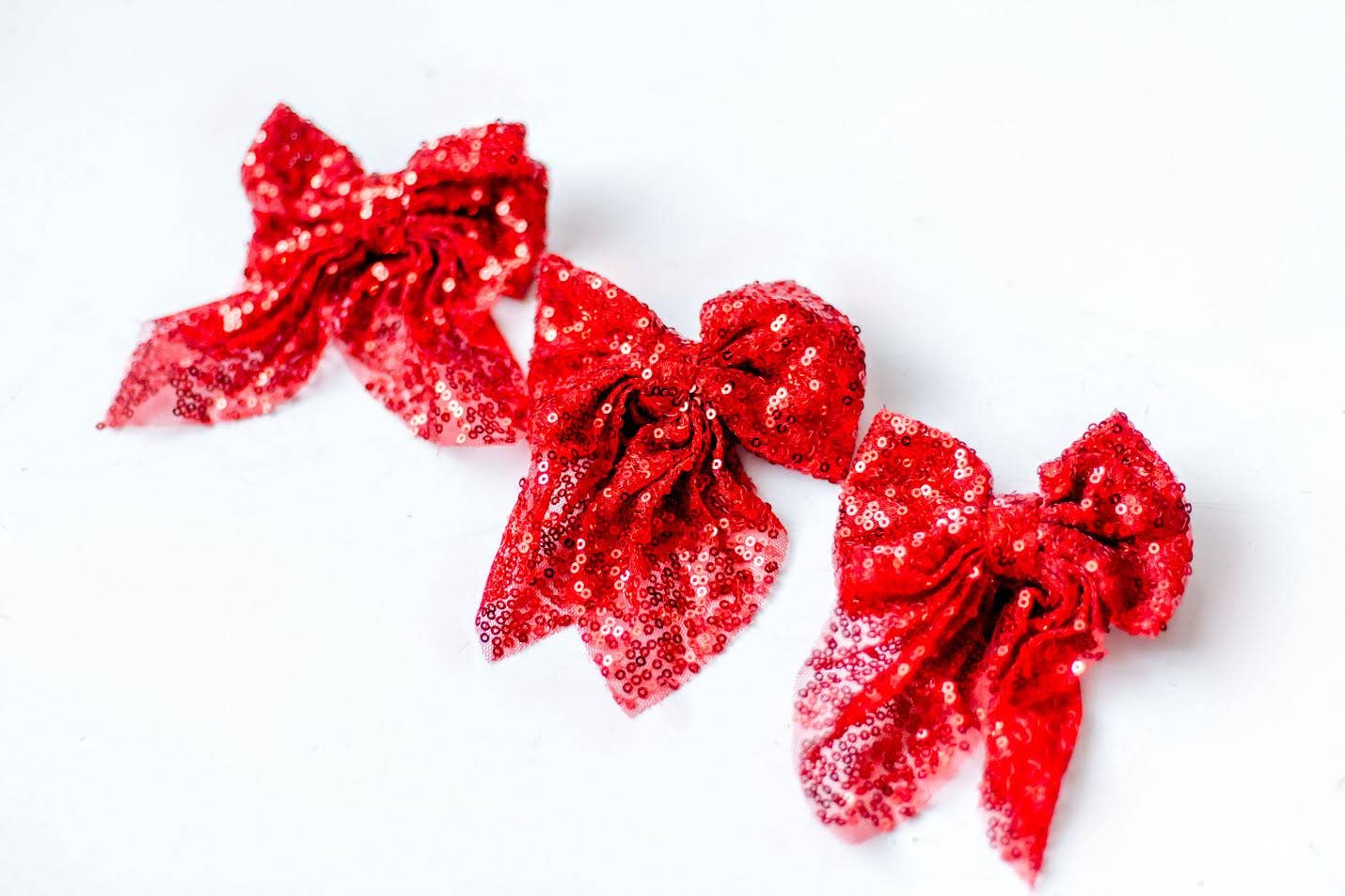 Red sequin hair bow with a shiny, sparkly finish and a 4-inch clip for easy styling.