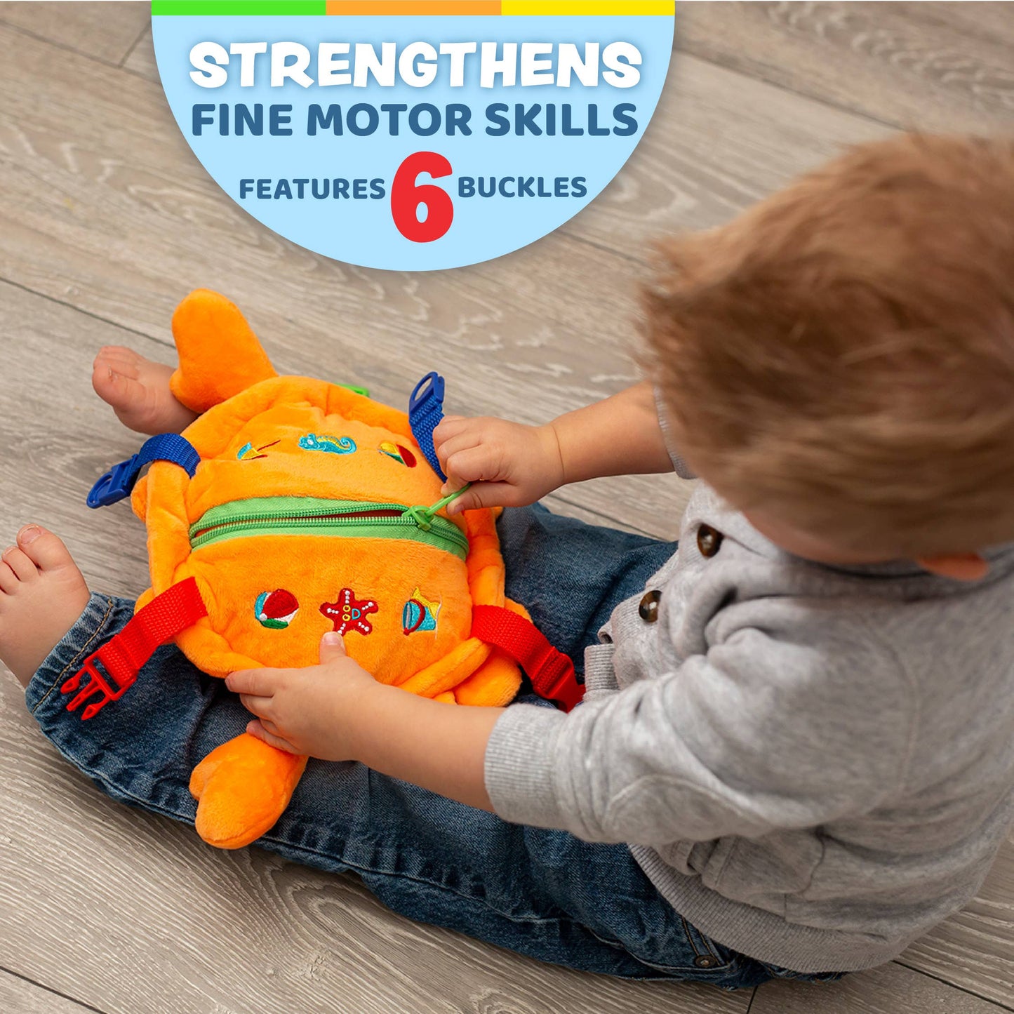 Bright orange plush crab toy with colorful buckles and a green zipper, perfect for sensory play.