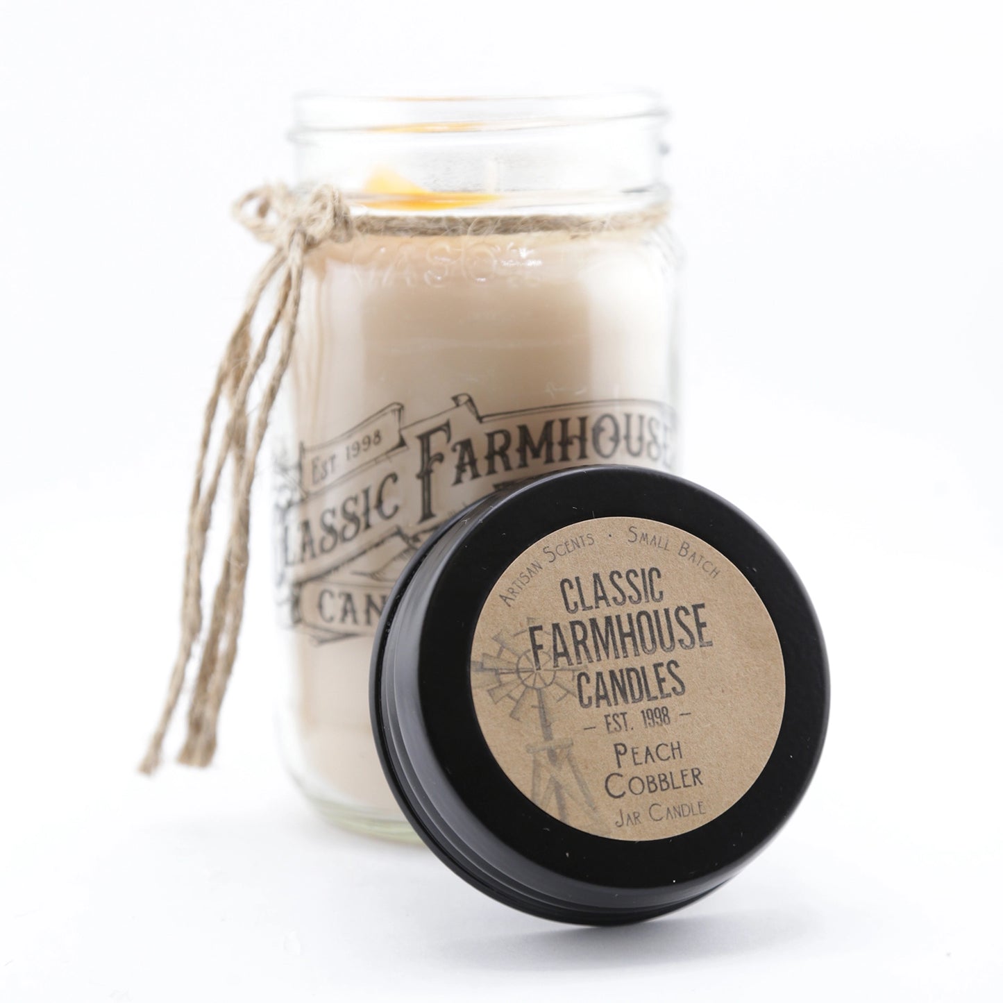 Classic farmhouse-style candle in a mason jar with rustic twine and a black lid labeled "Peach Cobbler".