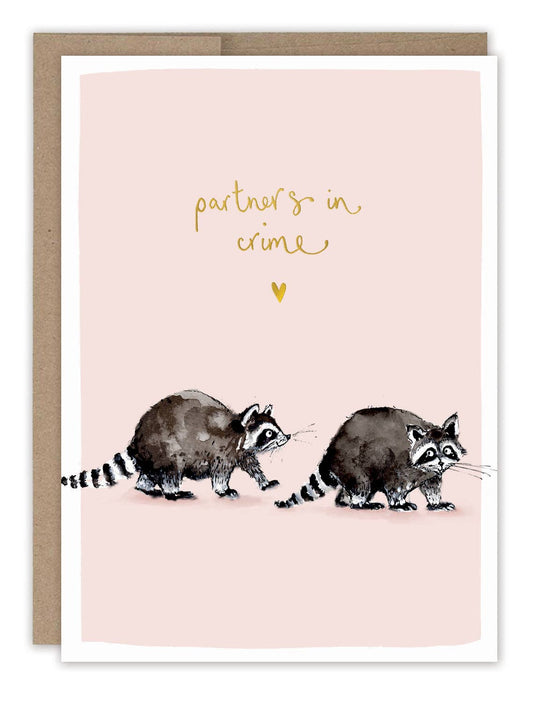 Illustrated raccoons on a pink card with 'partners in crime' text in gold foil