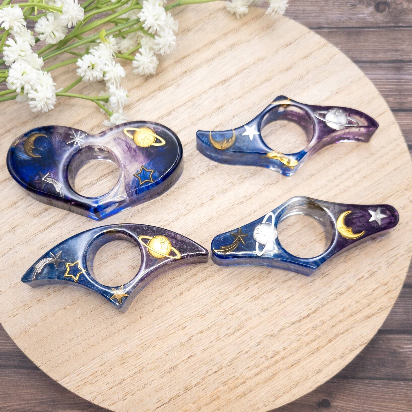 Purple and blue resin book page holder with galaxy design, featuring planets and stars.