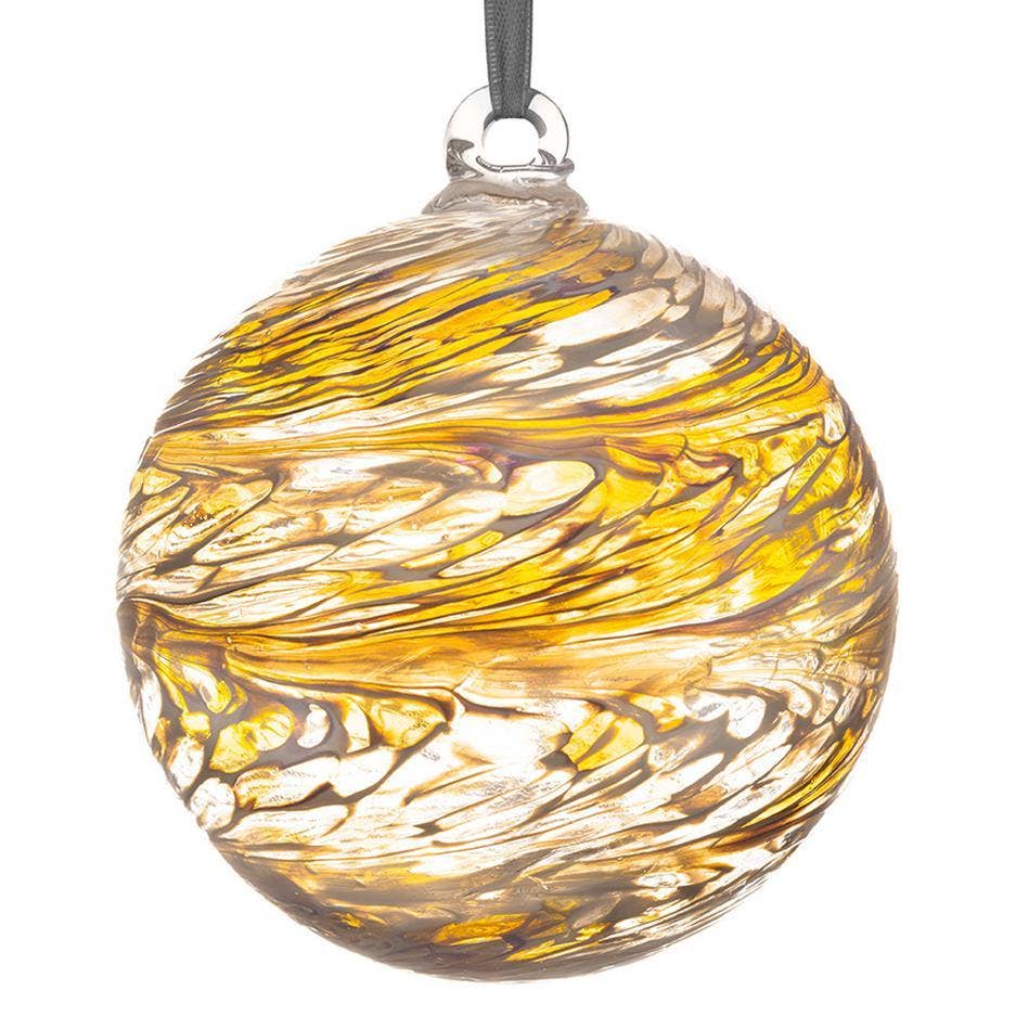 Round glass ornament in pastel gold tones with gentle swirl patterns, suspended with a soft ribbon.