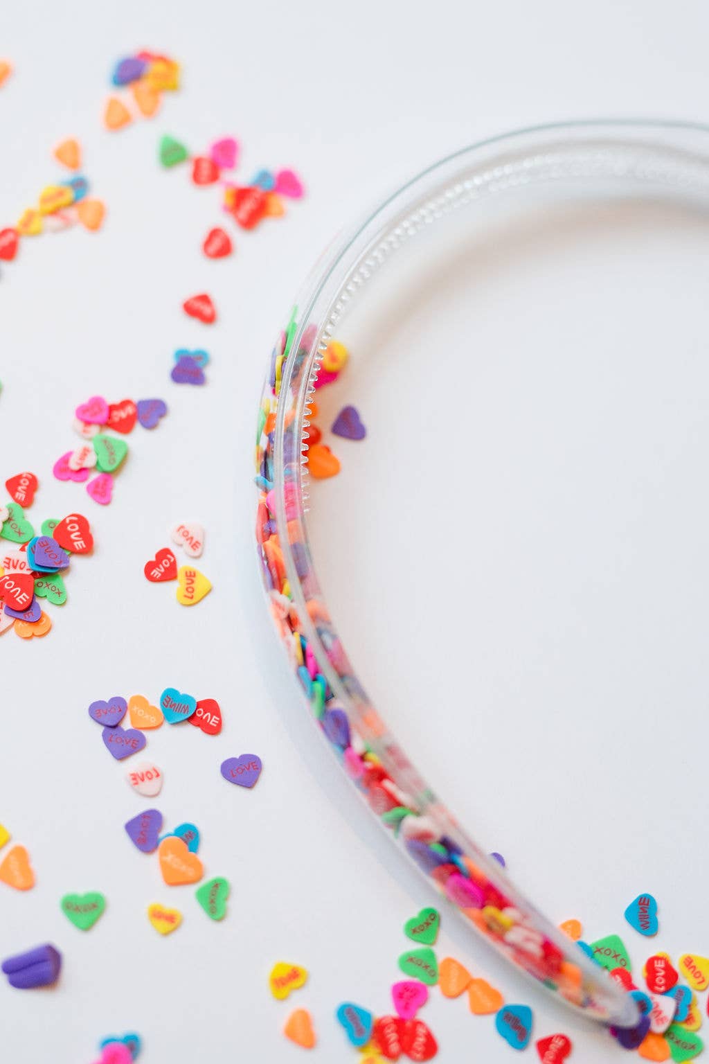 A clear plastic headband filled with colorful heart-shaped confetti, perfect for gifts.