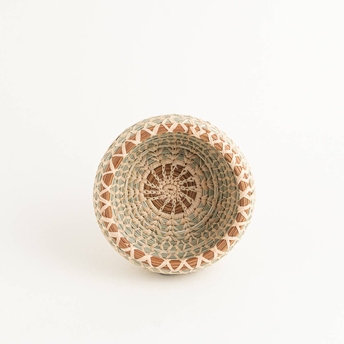 Handwoven desk basket with pine needle trim, featuring a natural, earthy design and intricate pattern.