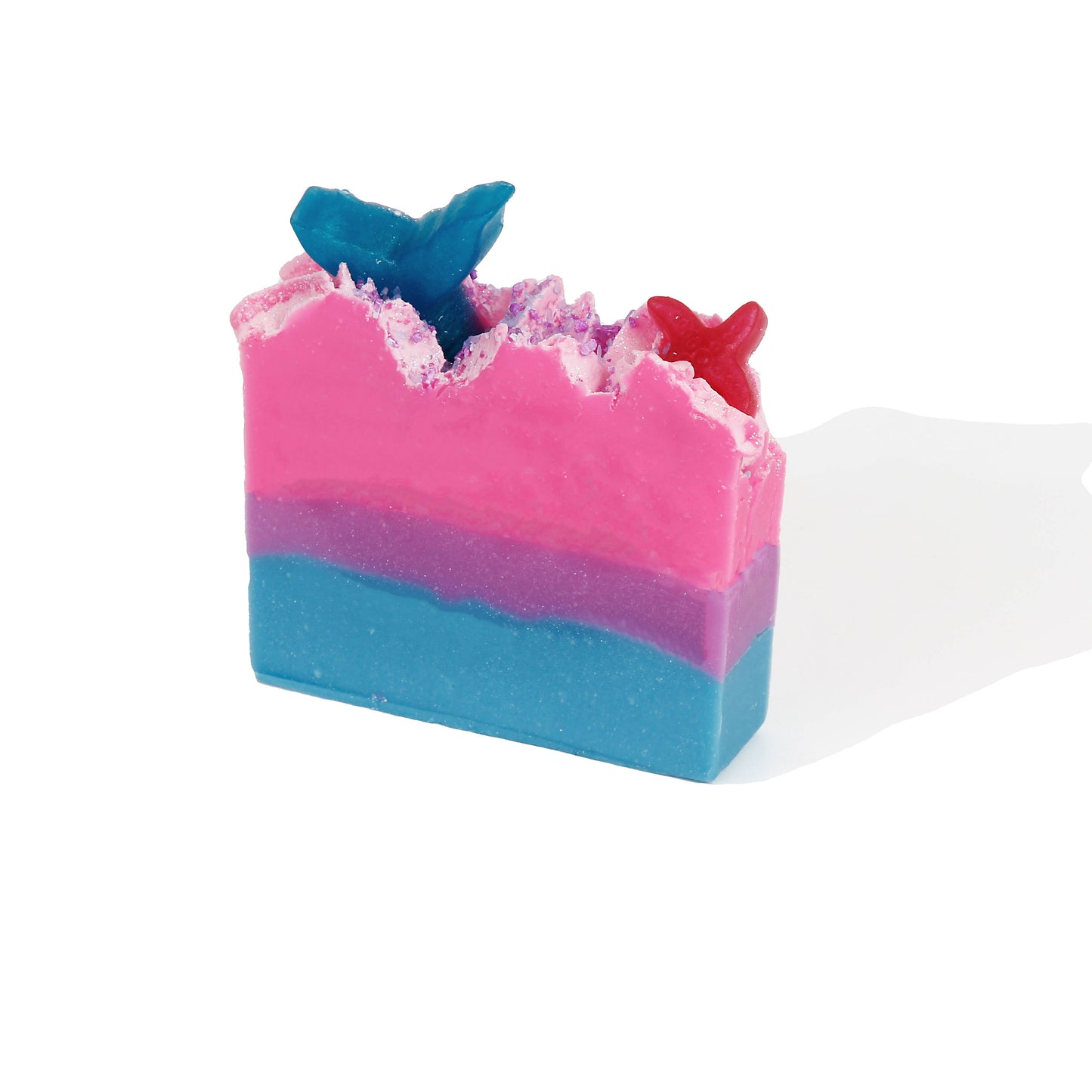 Colorful layered mermaid-themed bar soap with tail designs on top
