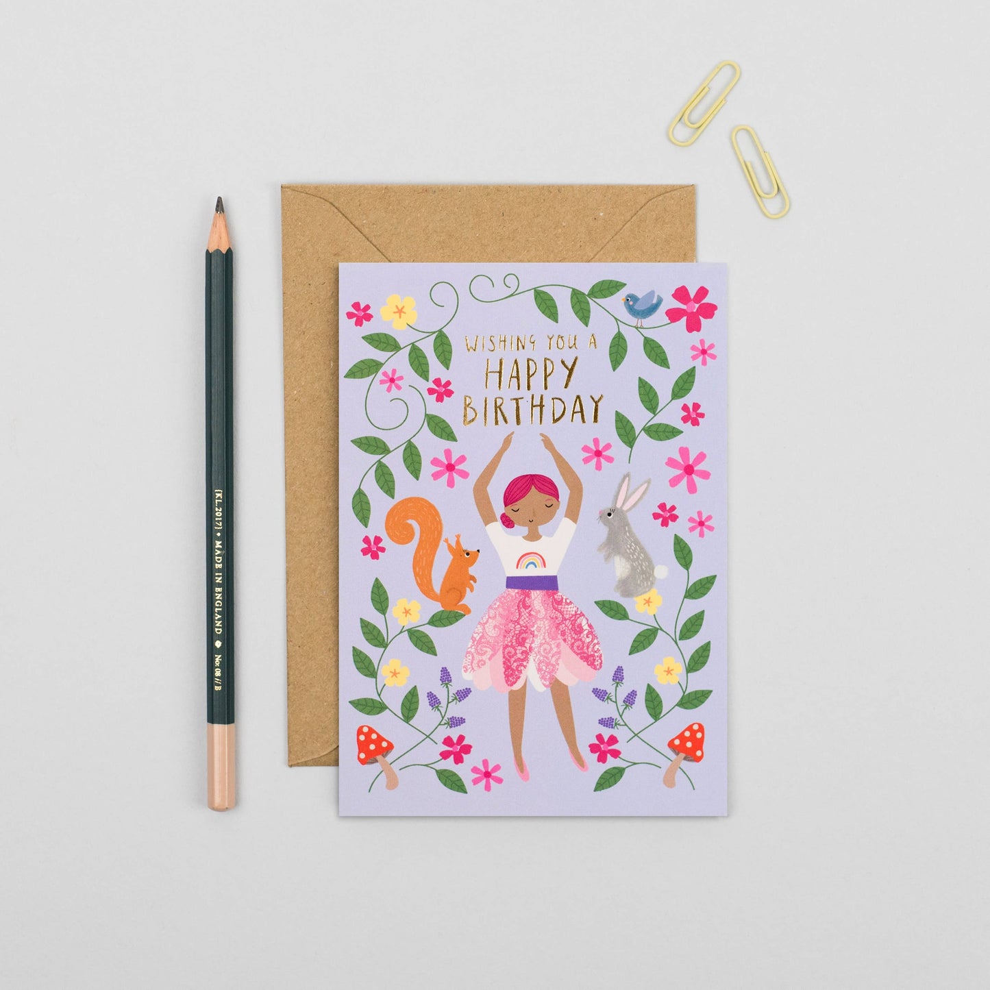 Children's birthday card with dancing girl, forest animals, and floral design