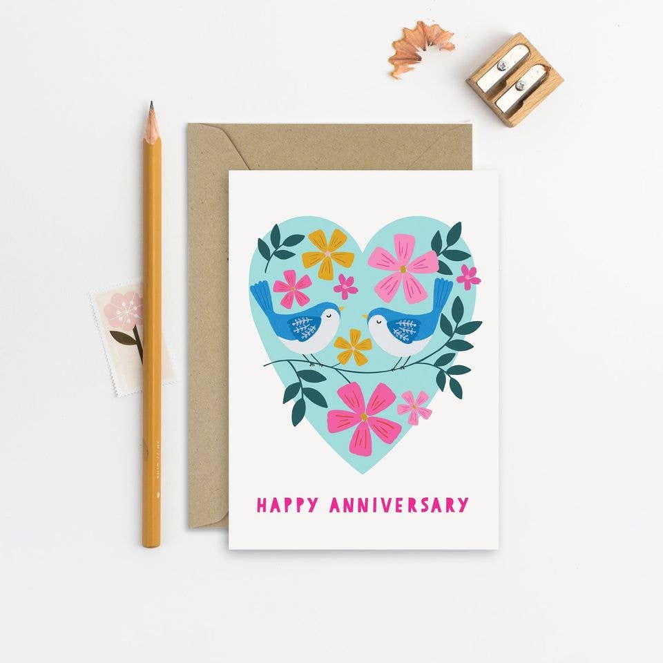Anniversary card with two blue birds and colorful flowers inside a heart shape