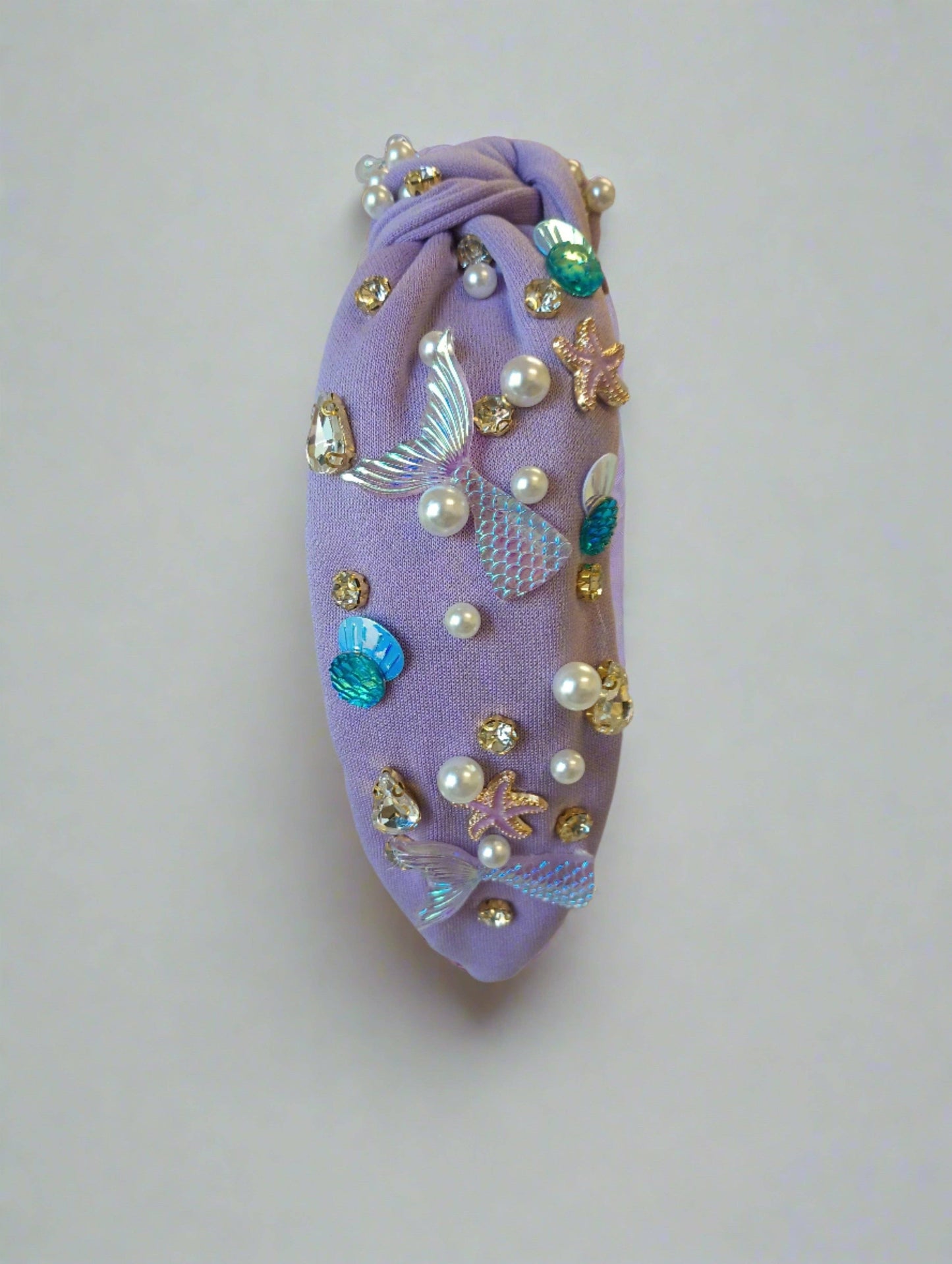 Purple beaded headband adorned with mermaid tails, pearls, and starfish accents for a magical look.