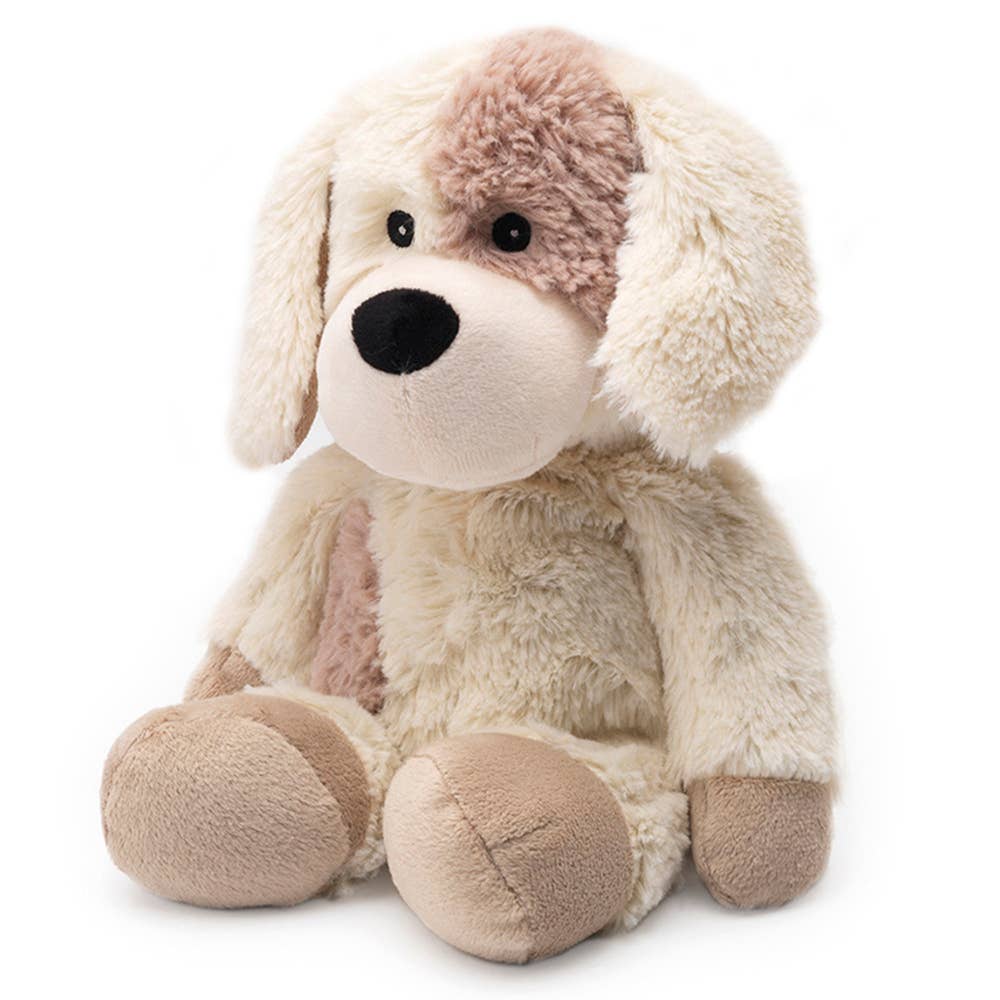 Cream-colored plush puppy with a tan ear patch, floppy ears, and soft, cuddly appearance.