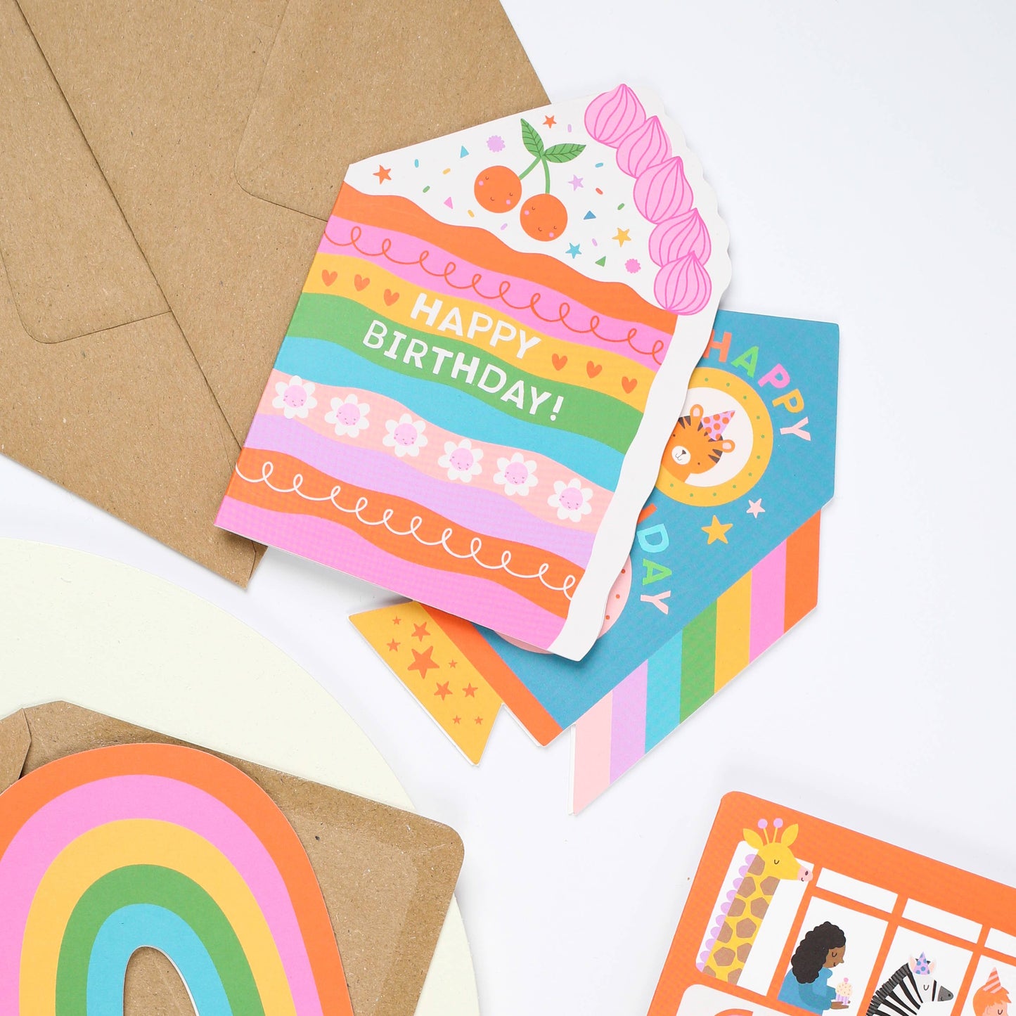 A colorful rainbow birthday card shaped like a cake with "Happy Birthday!" written on it.