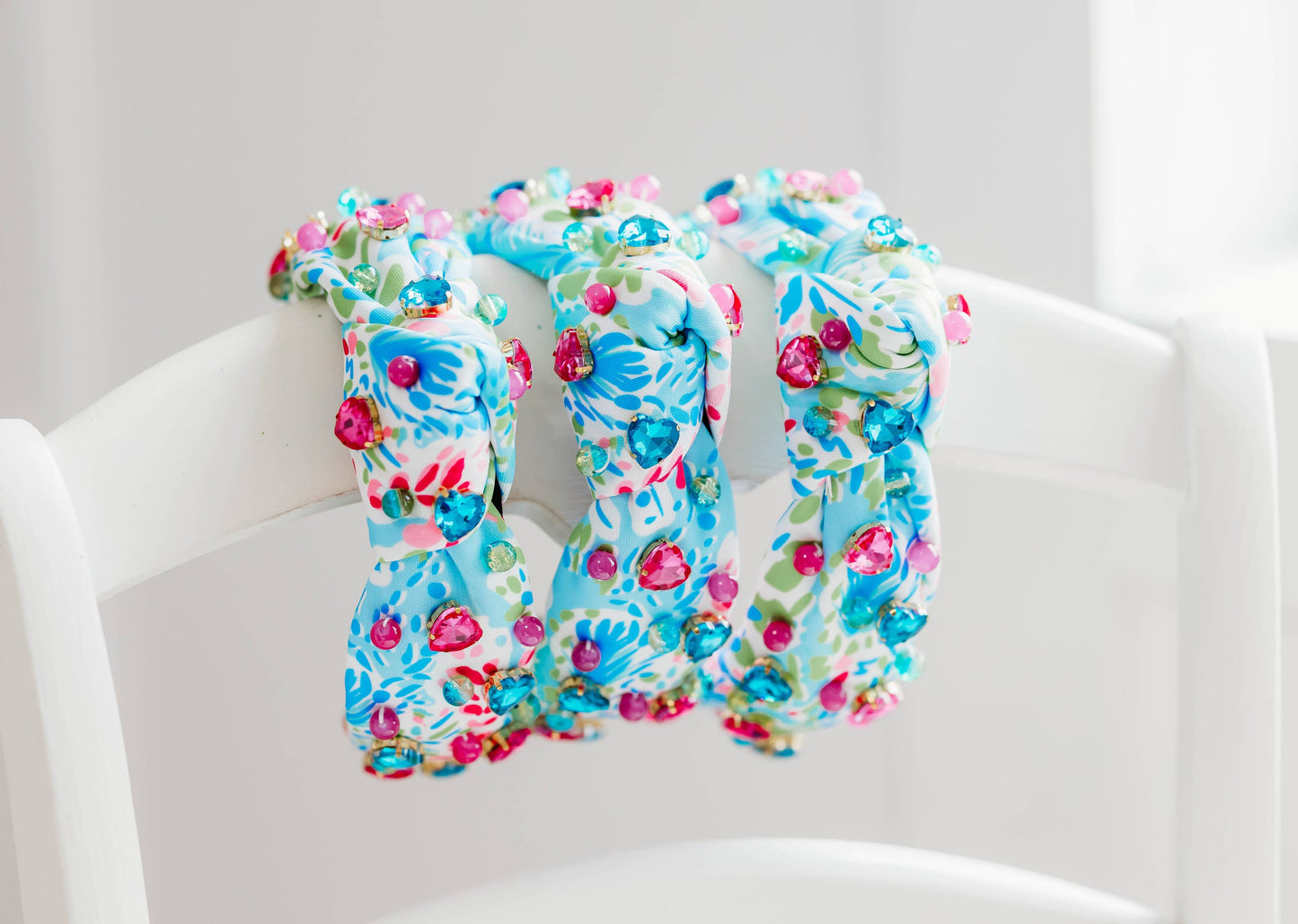 A beaded headband with tropical gemstones in Crystal Cove, featuring vibrant blue and green fabric adorned with colorful crystals.