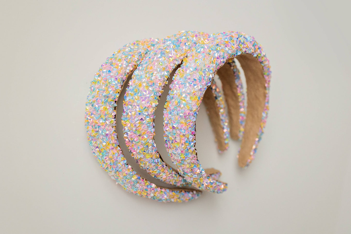 A handmade beaded headband with iridescent crystals in pastel colors.
