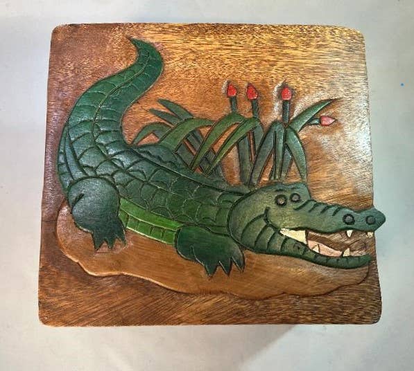 Hand-carved wooden stool featuring a green alligator design with red accents, perfect for unique adult gifts.