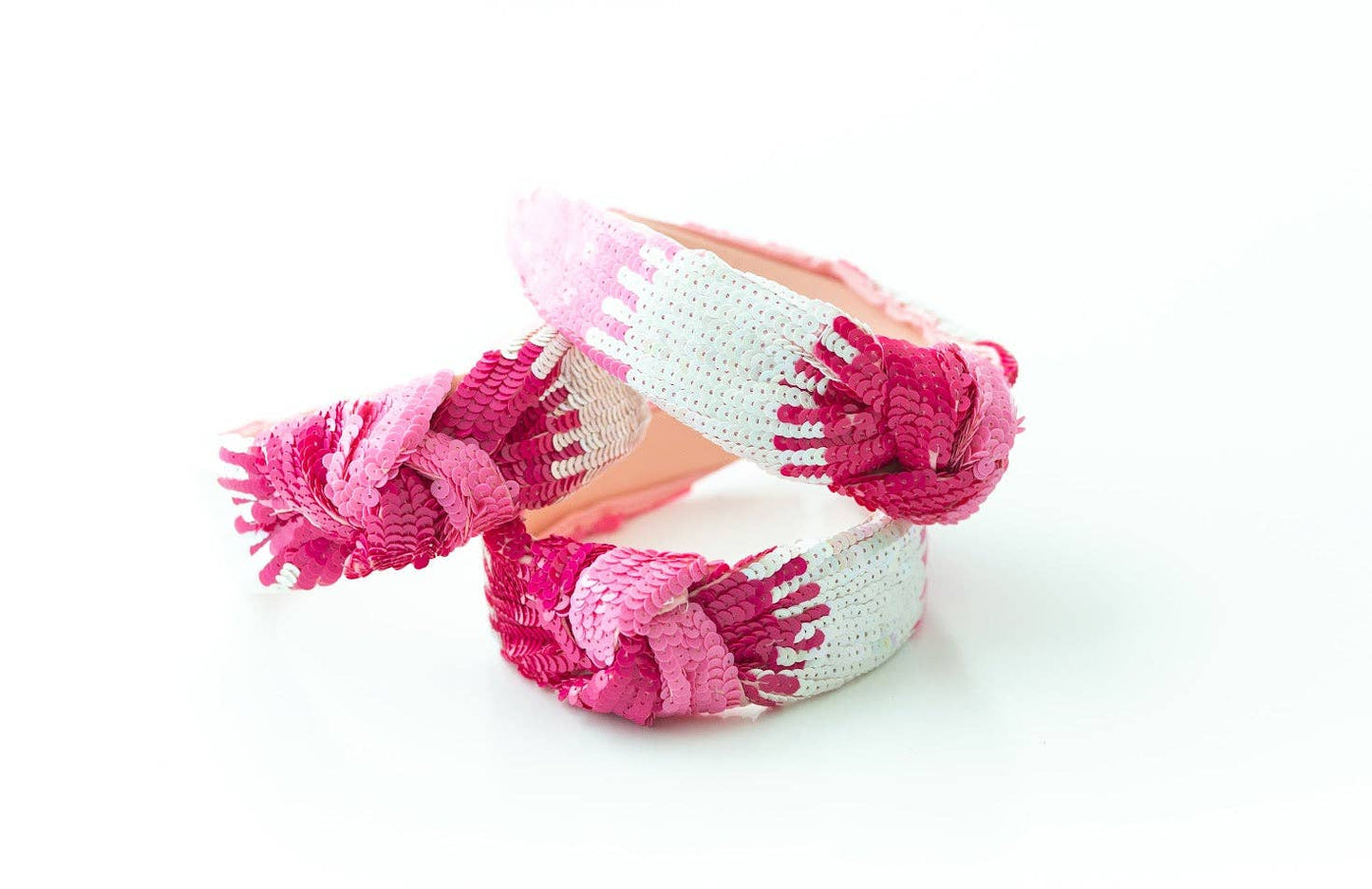 A beaded headband with a pink and white sequin ombre design, showcasing craftsmanship.