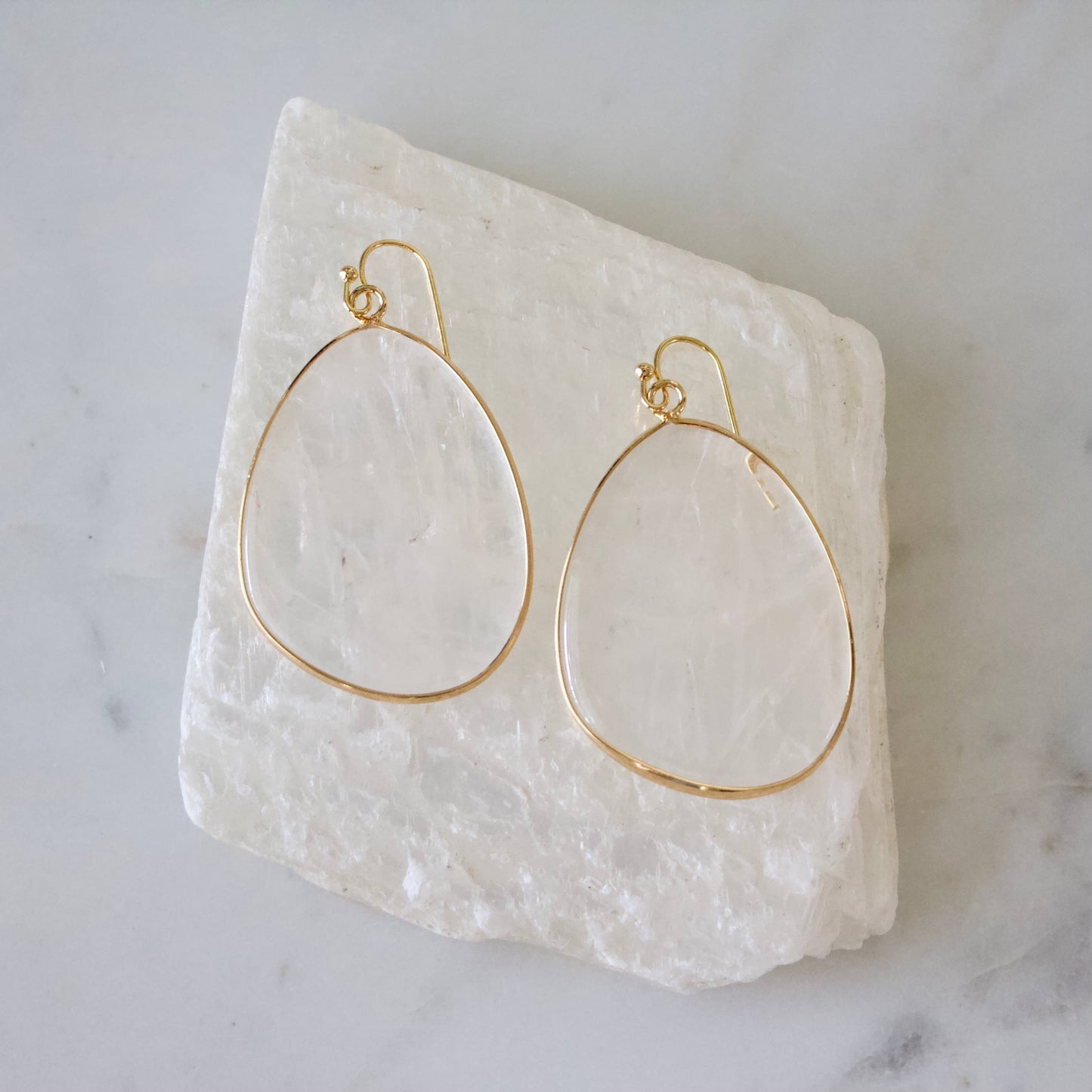 Teardrop-shaped quartz slab earrings with gold outlines, perfect for a unique gift.