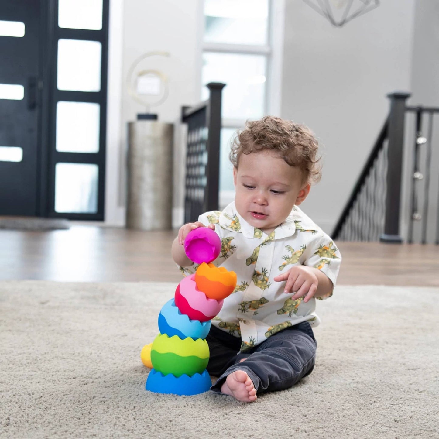 Brightly colored stacking toy with tactile texture, featuring interlocking pieces in vibrant rainbow hues.