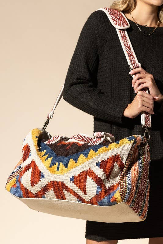 Large handmade duffel bag in woven Navajo-inspired patterns, with colorful geometric designs and a wide shoulder strap.
