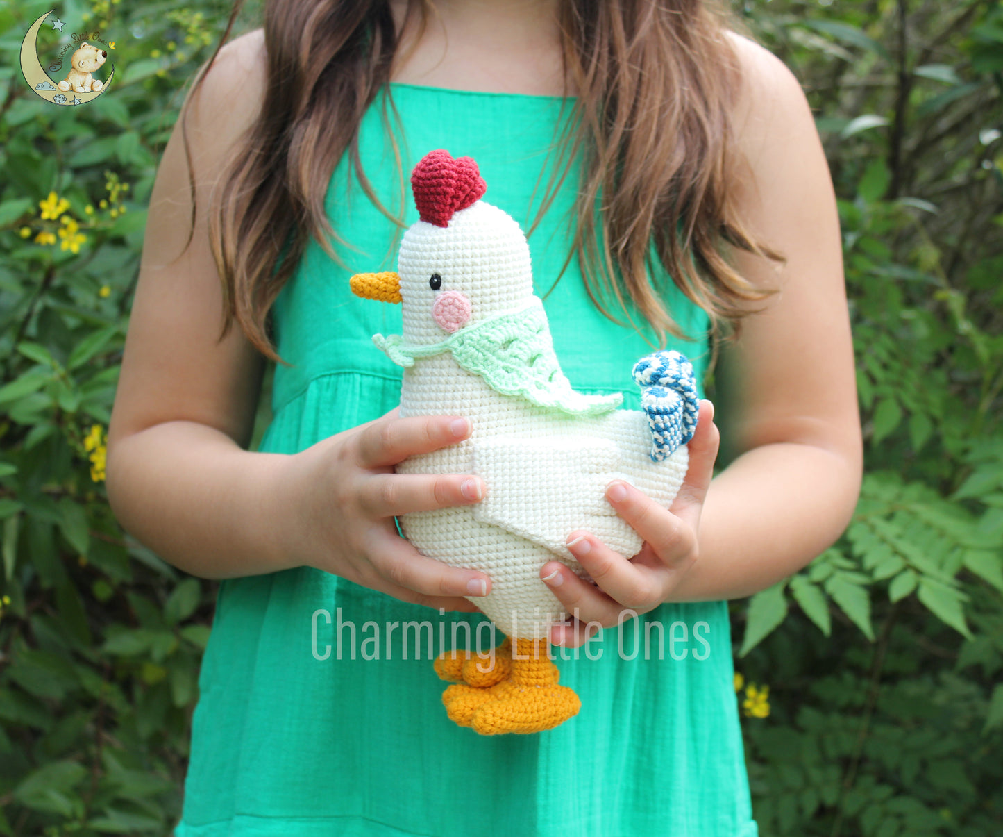 Handmade crochet chicken with white body, yellow feet, red comb, and blue bow, perfect for cuddling.