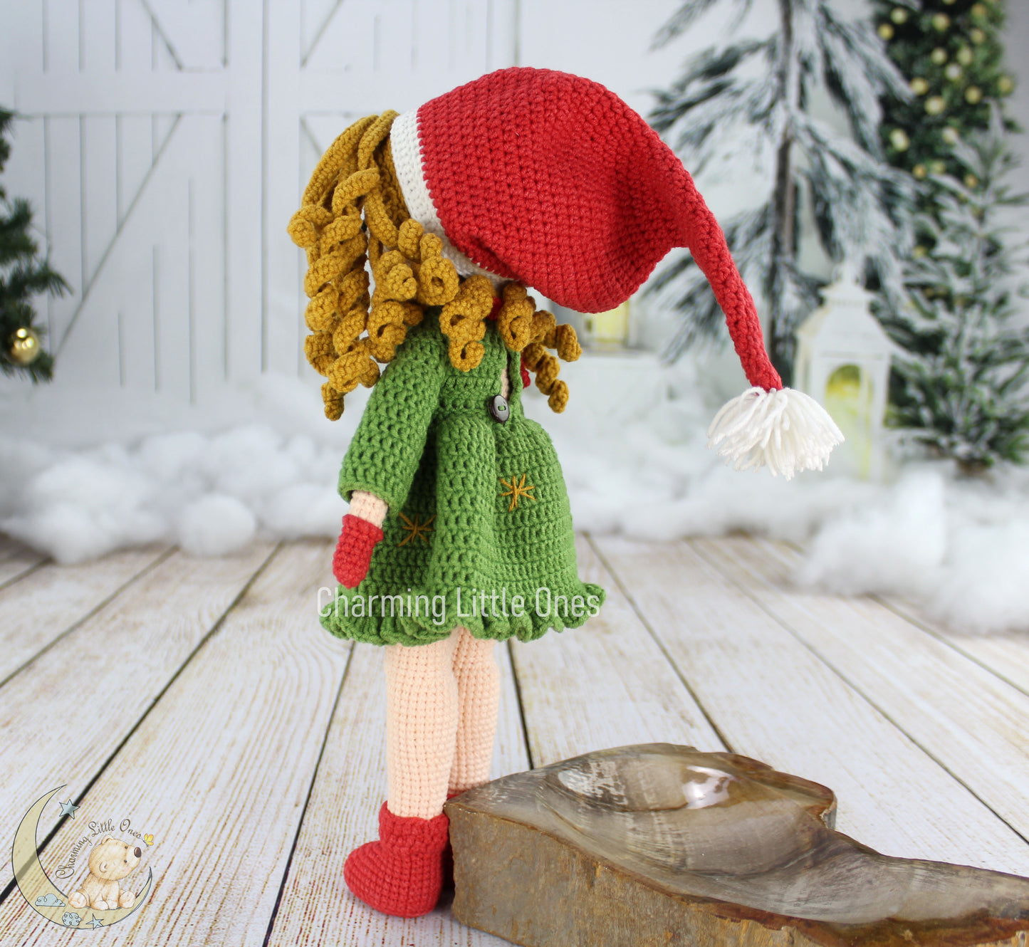 Crochet doll with curly yellow hair, red Santa hat, green coat, and red boots, perfect for Christmas.