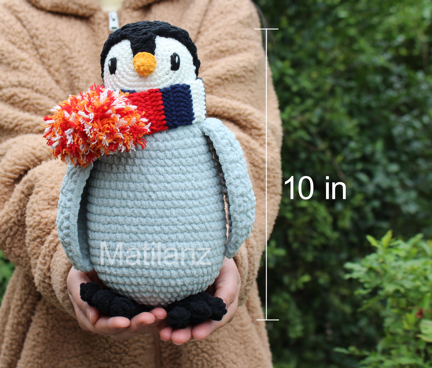 A handmade crochet penguin toy with a scarf, 10 inches tall.
