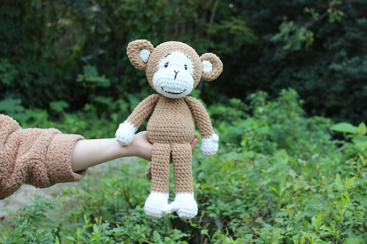 Handmade crochet monkey plush, 11 inches tall, with brown and white yarn, smiling face, and long arms.