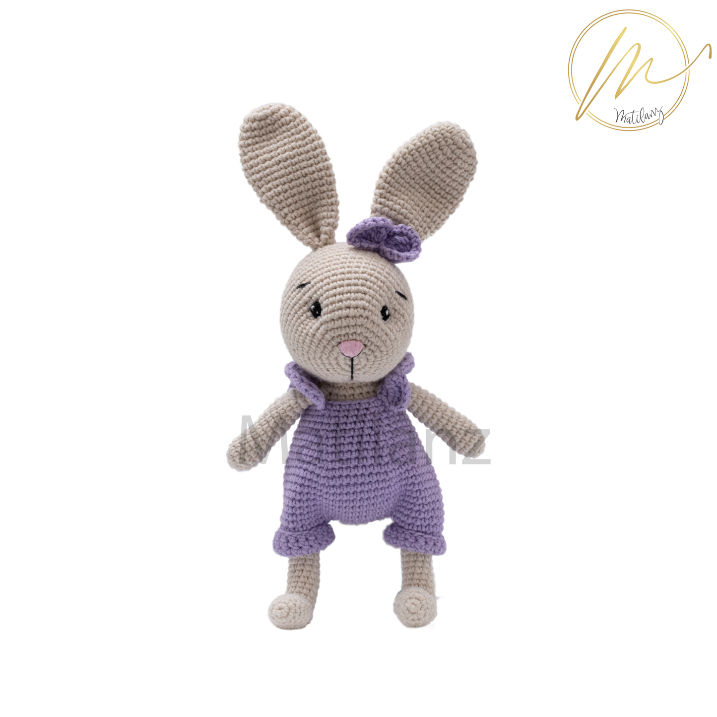 Handmade crochet rabbit in pastel colors, wearing a purple bow and matching overalls.