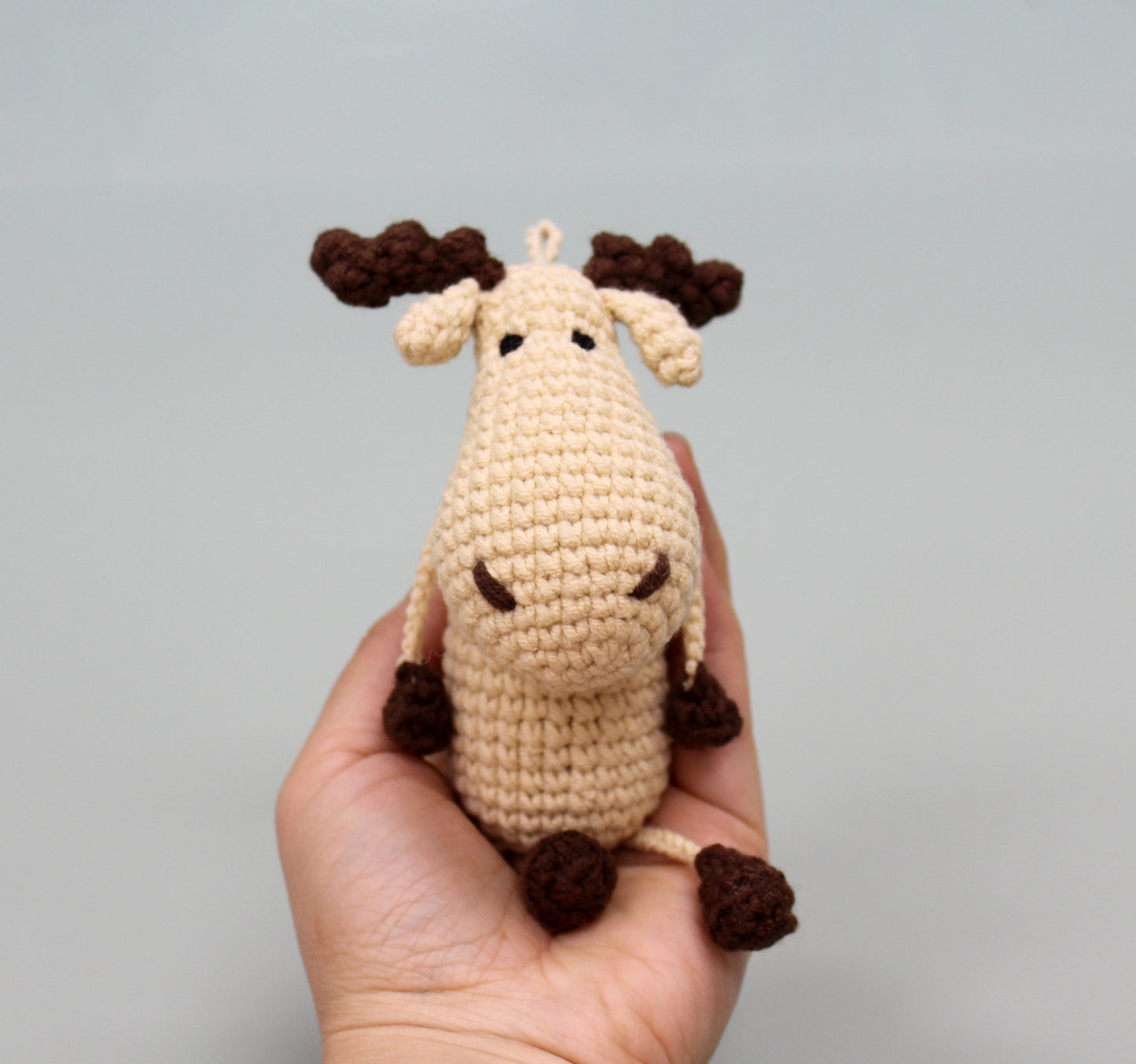 Handmade crochet moose keychain with cream body and brown antlers, crafted in plush.