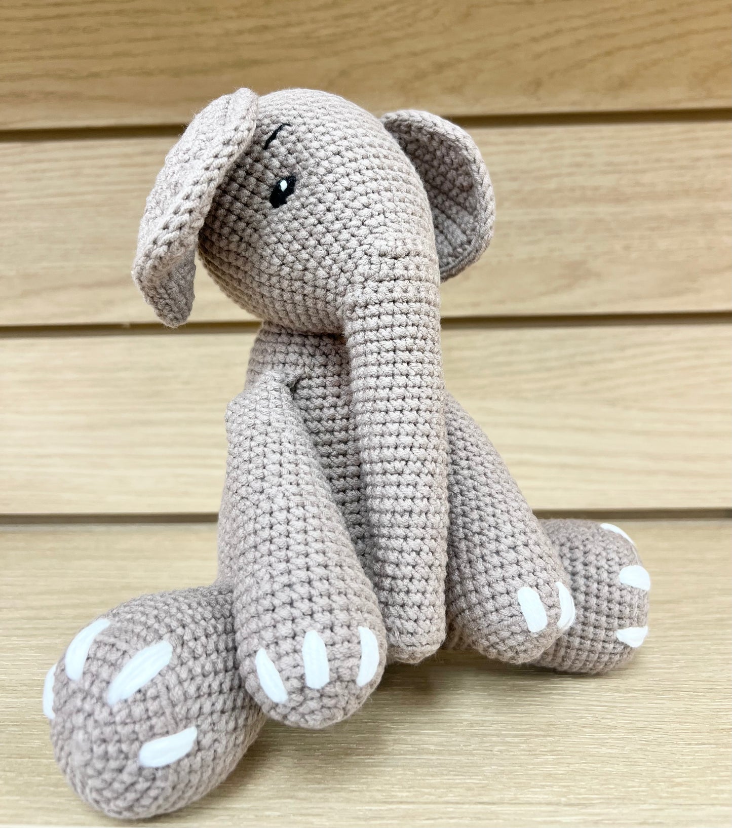Handmade crochet elephant, 8 inches tall, with beige yarn, white paw pads, and charming crochet eyes.