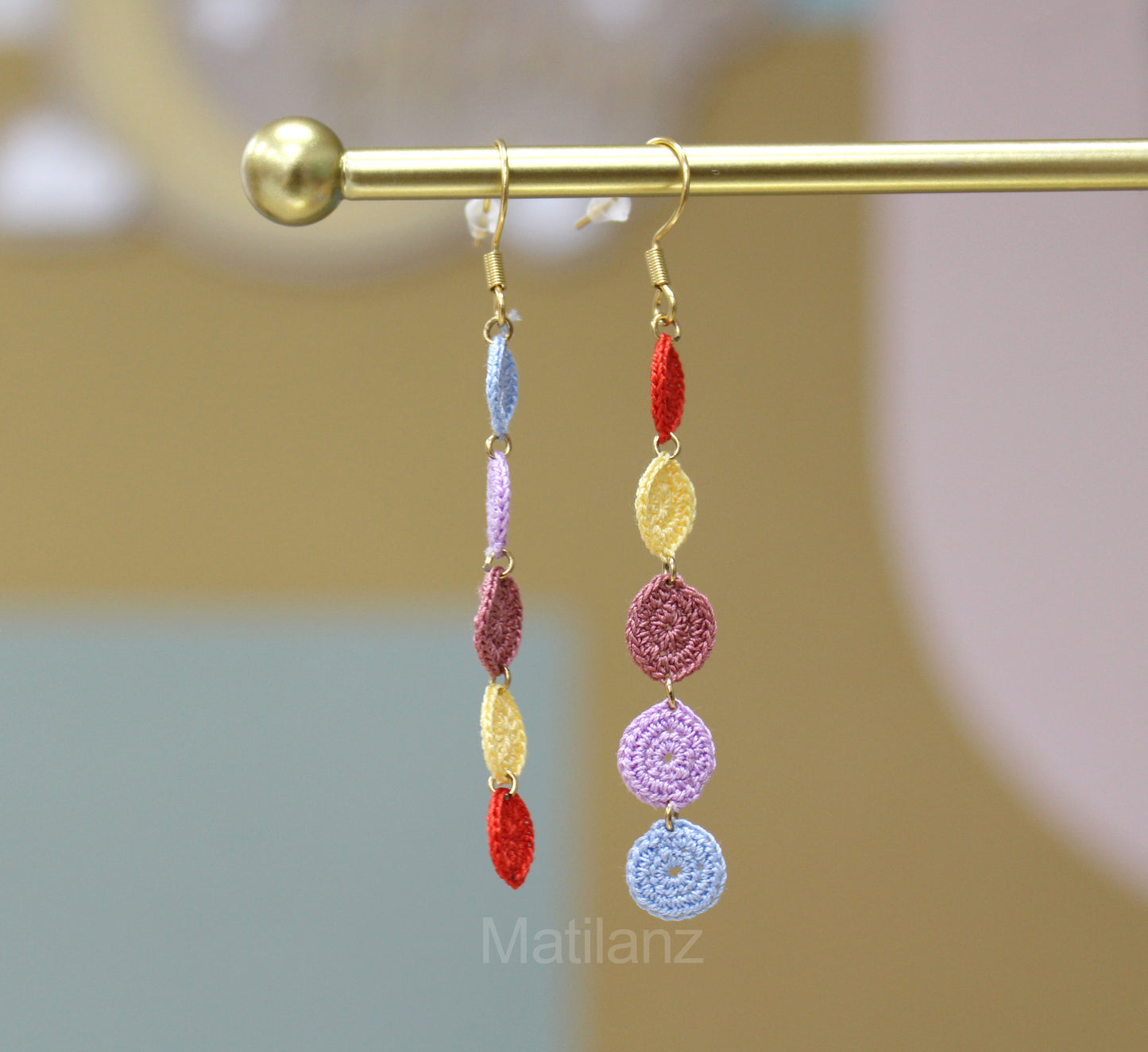 Handmade crochet earrings featuring colorful, circular and leaf-shaped charms in vibrant hues.