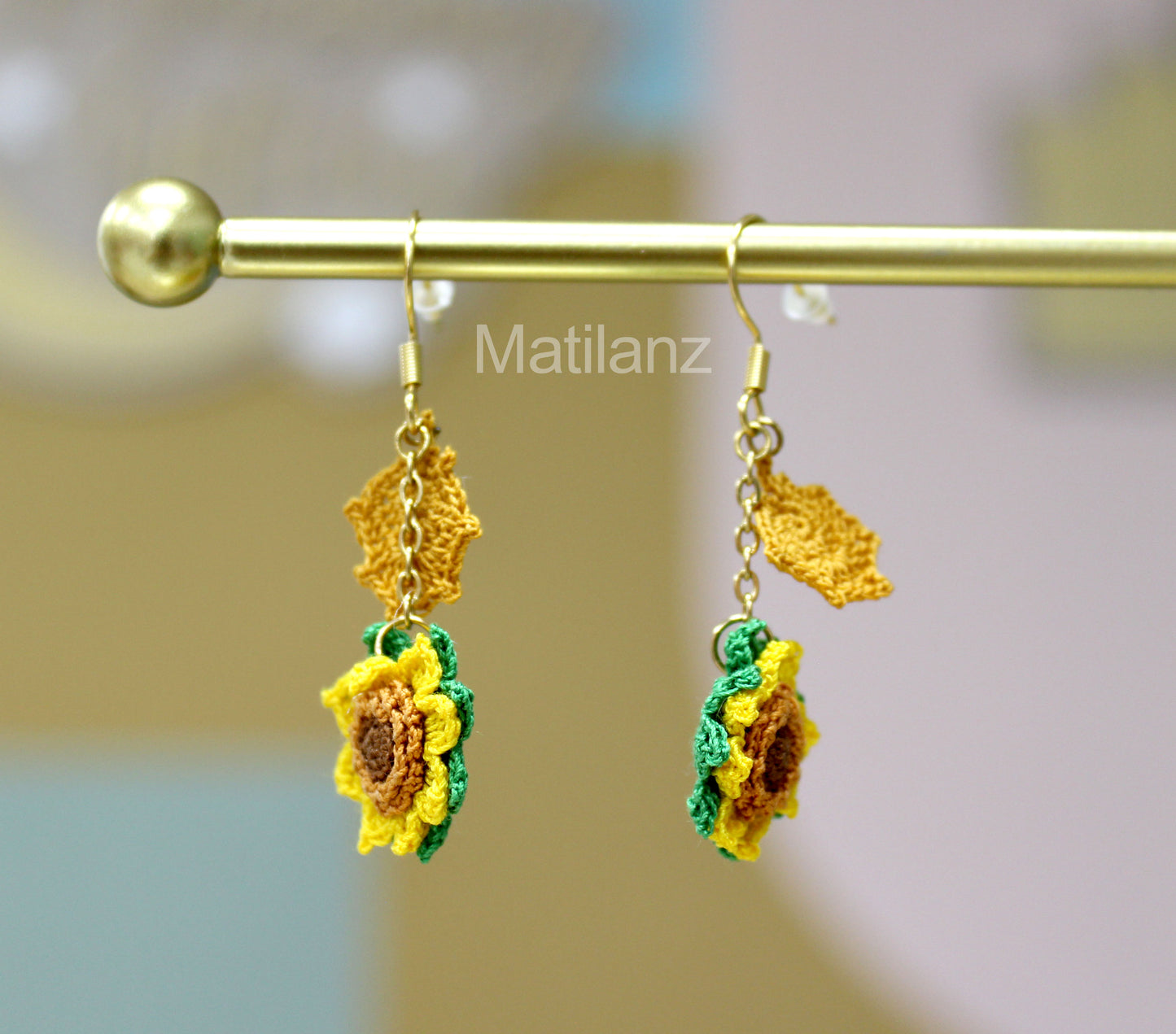 Handmade crochet earrings featuring yellow sunflowers with green leaves and brown centers, perfect for nature lovers.