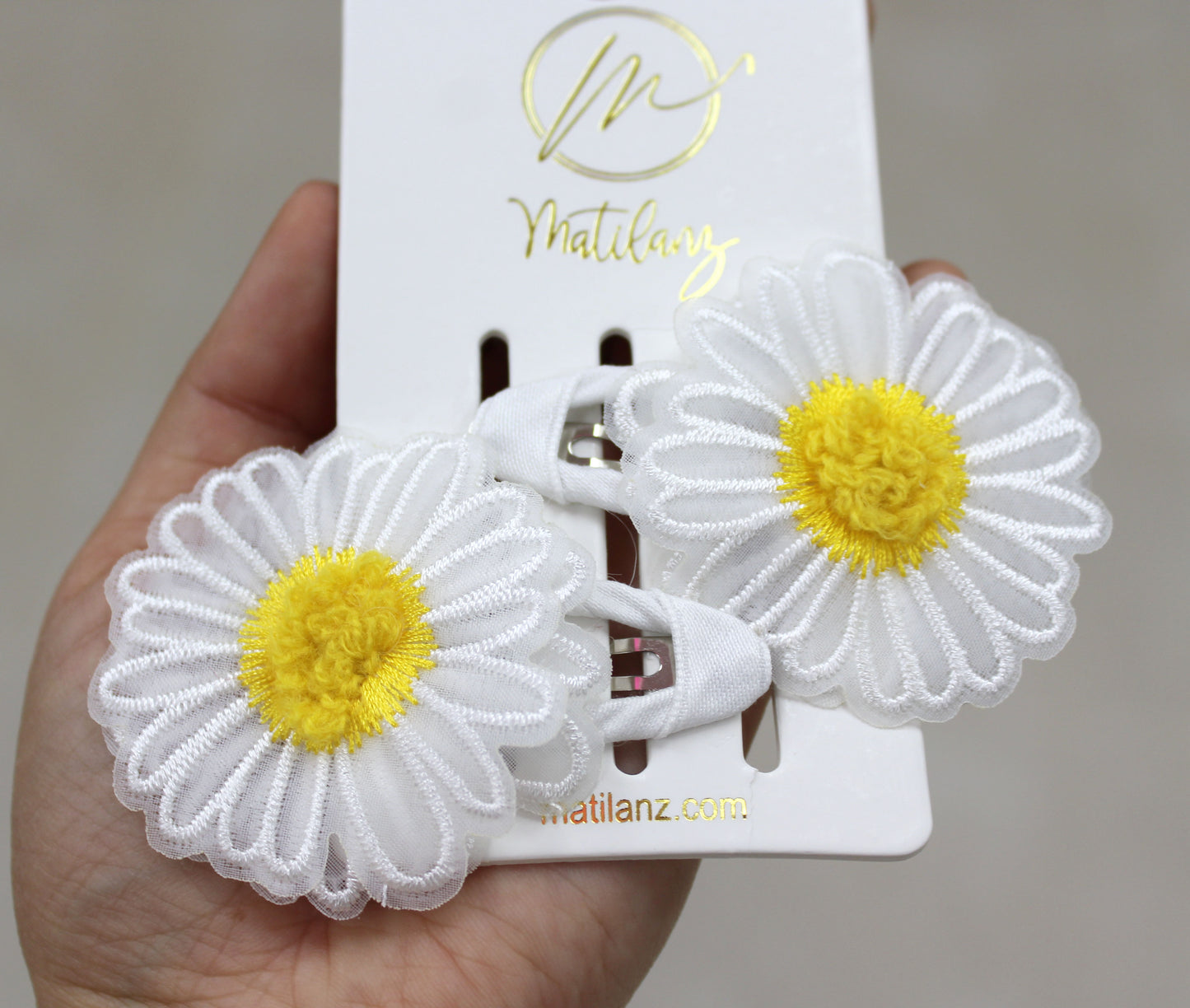 White floral embroidery hair clips with yellow centers, set of 2.