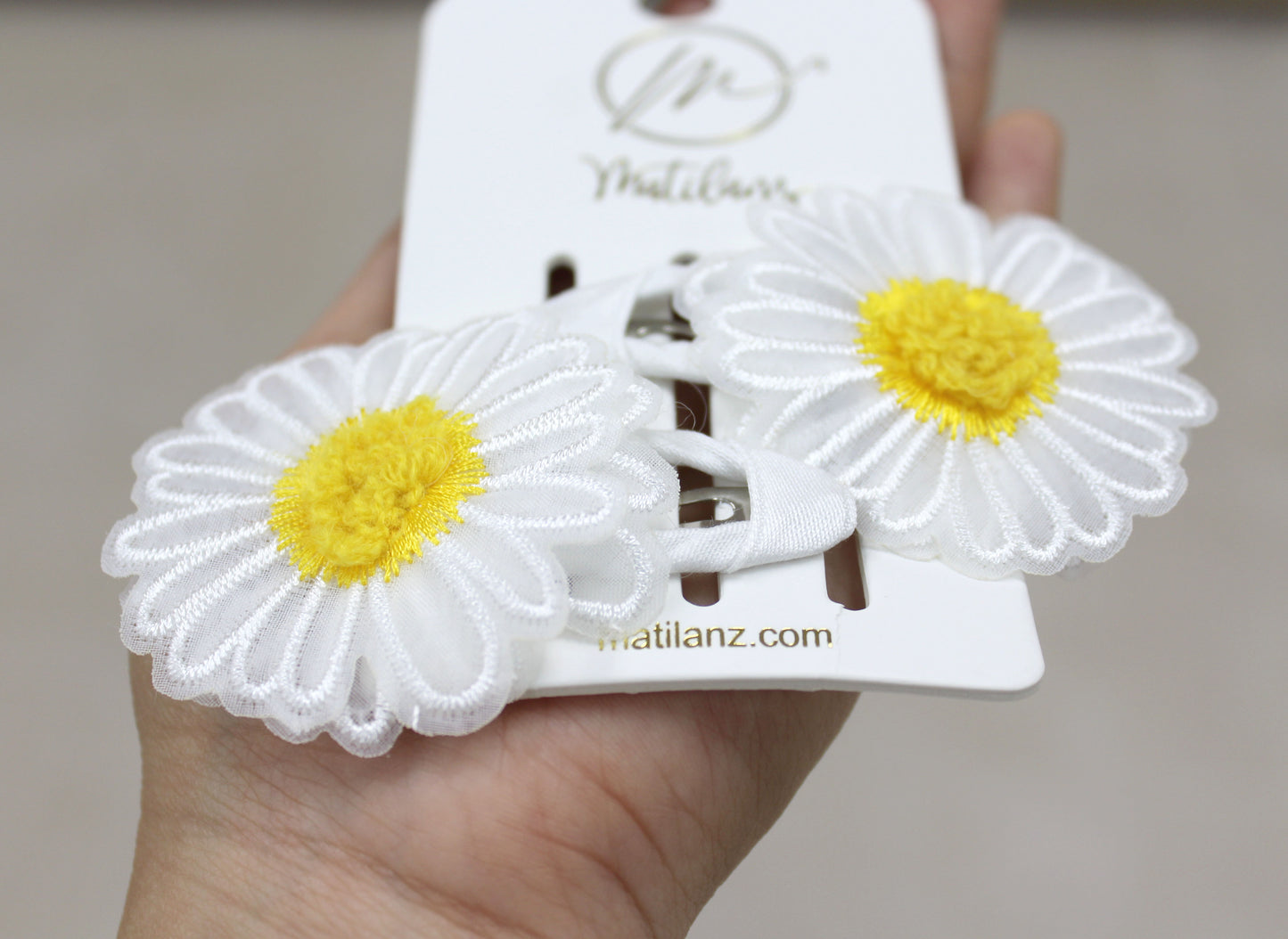 White floral embroidery hair clips with yellow centers, set of 2.