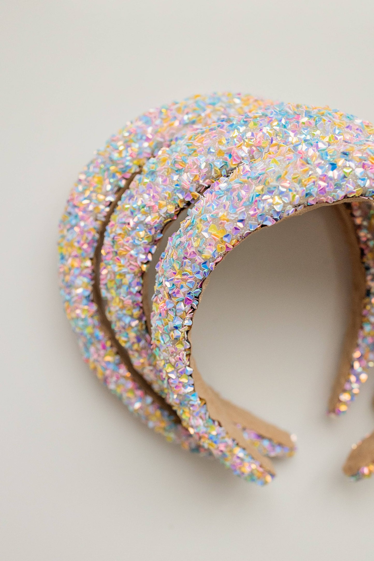 A beaded headband adorned with iridescent crystals in pastel hues, perfect for a festive look.