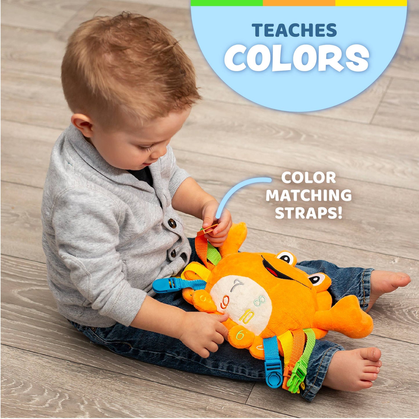 Bright orange plush crab toy with colorful buckles and straps for sensory play.