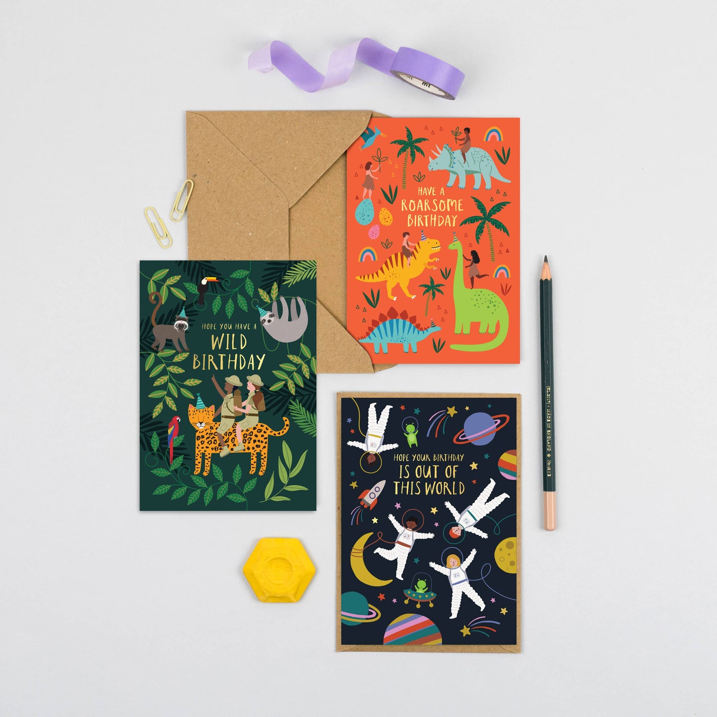 Bright orange dinosaur birthday card featuring kids riding colorful dinosaurs and playful jungle elements.