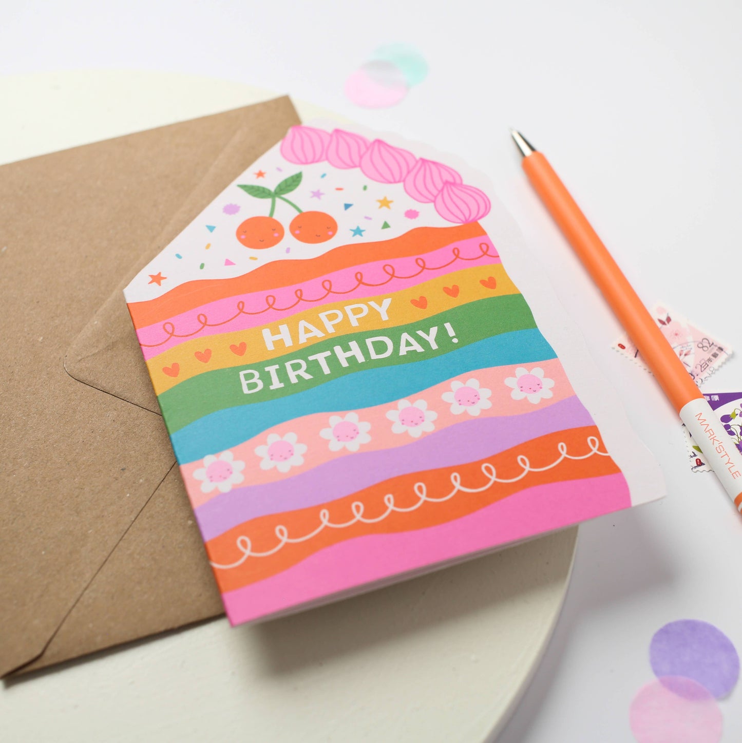 A colorful rainbow cake die-cut birthday card with "Happy Birthday!" text and cherries, perfect for unique gifts.