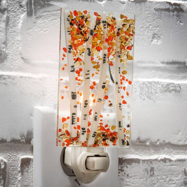 Fused glass night light with autumn aspen tree design plugged into wall