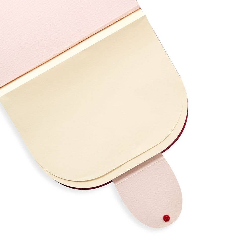Pink and cream cat-shaped sketchbook with red button details, perfect for travel art.