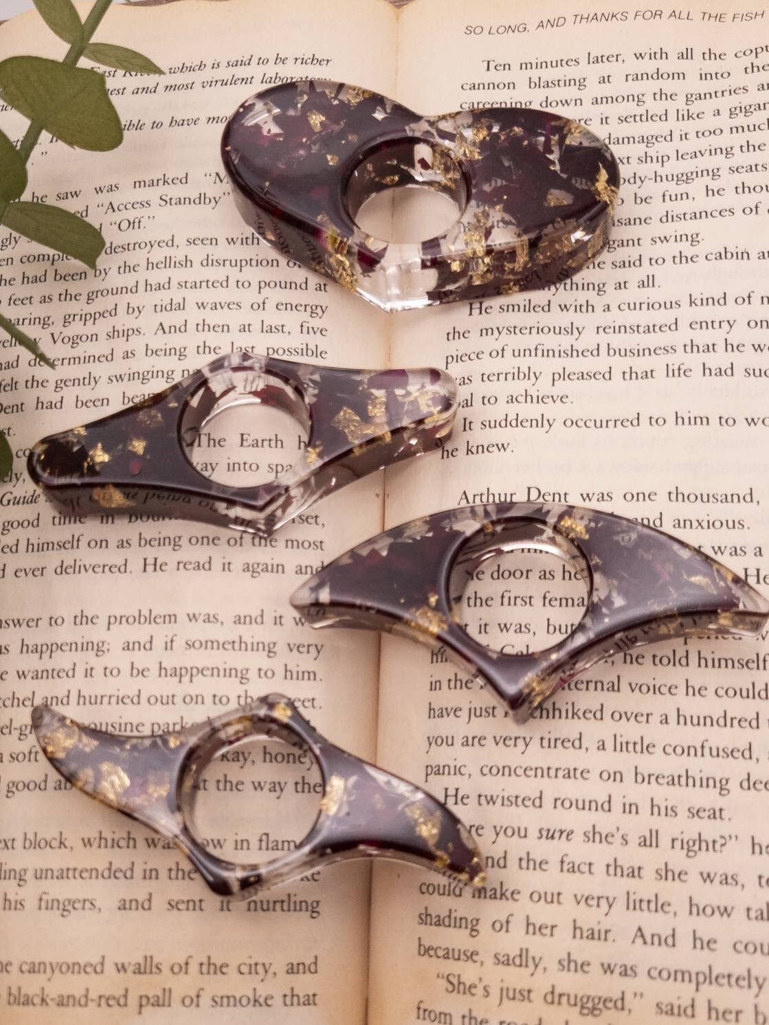 Resin book page holder with rose and gold flower design, featuring a sleek, curved shape for easy reading.