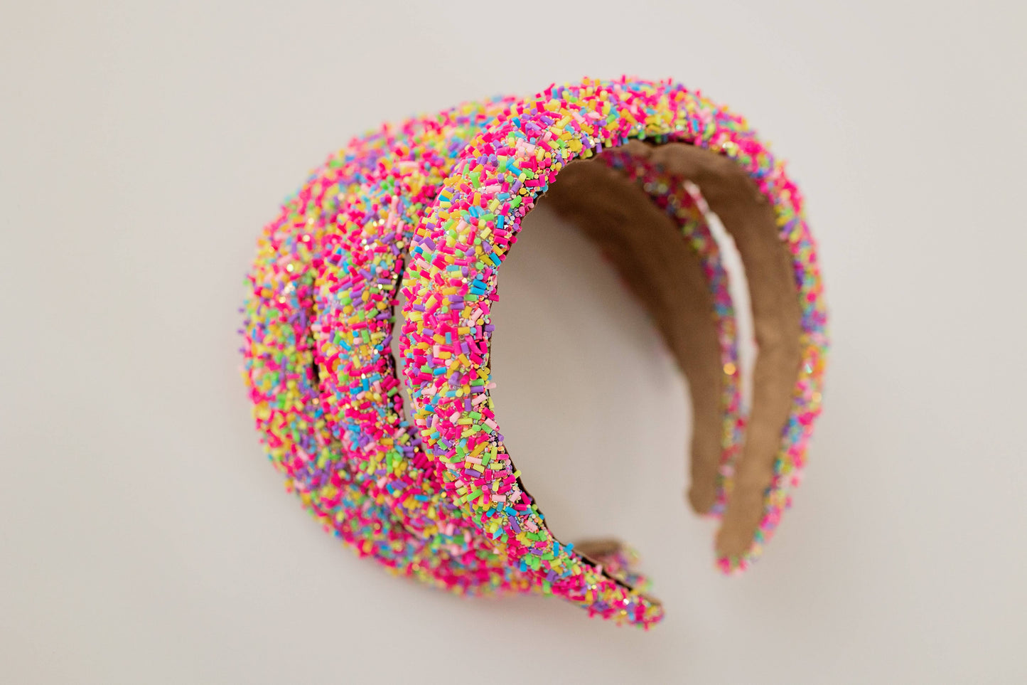 Pink beaded headband adorned with colorful sprinkles, perfect for fun and unique accessories.