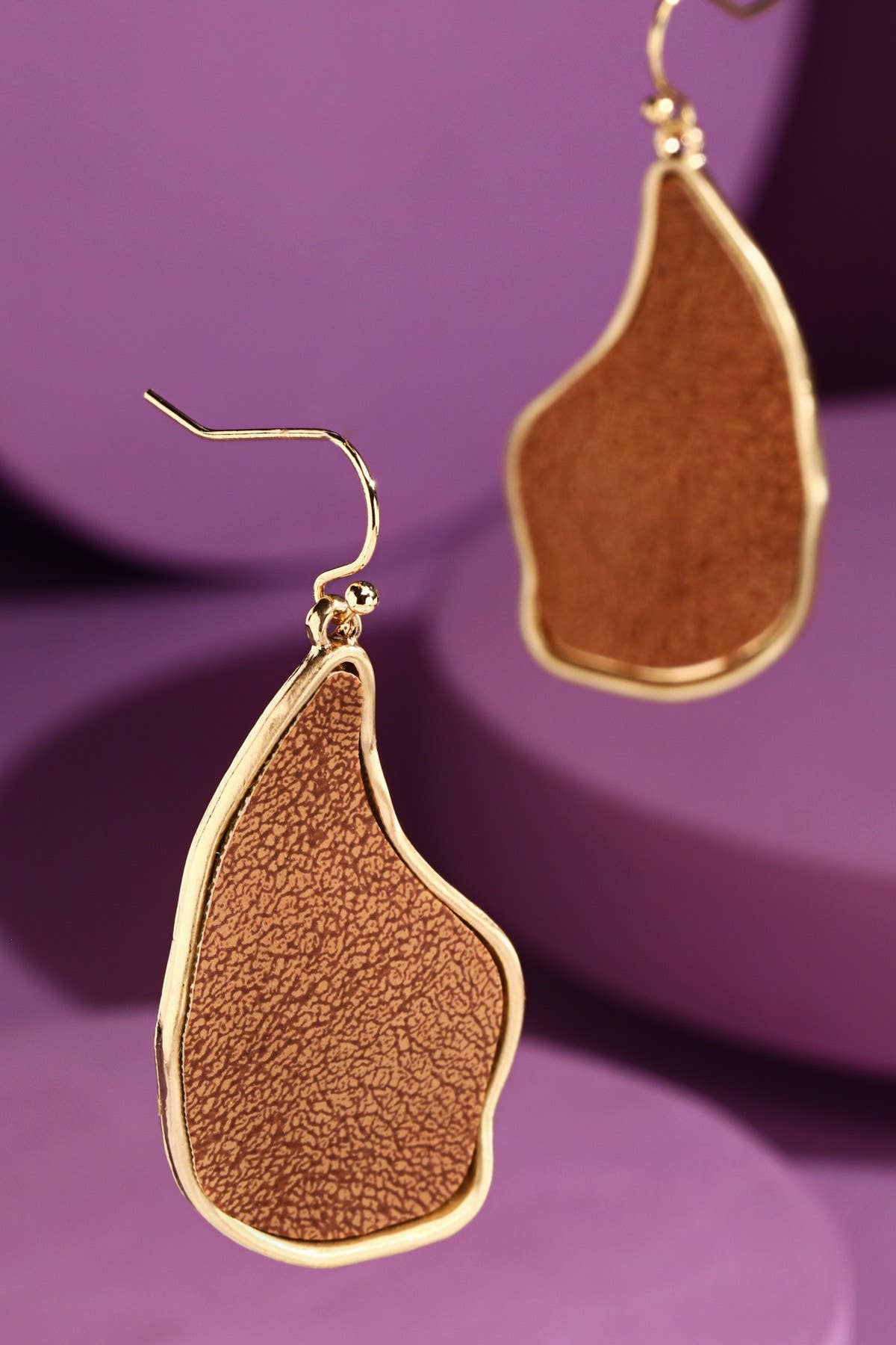 Brown organic-shaped dangle earrings with textured faux leather and gold trim
