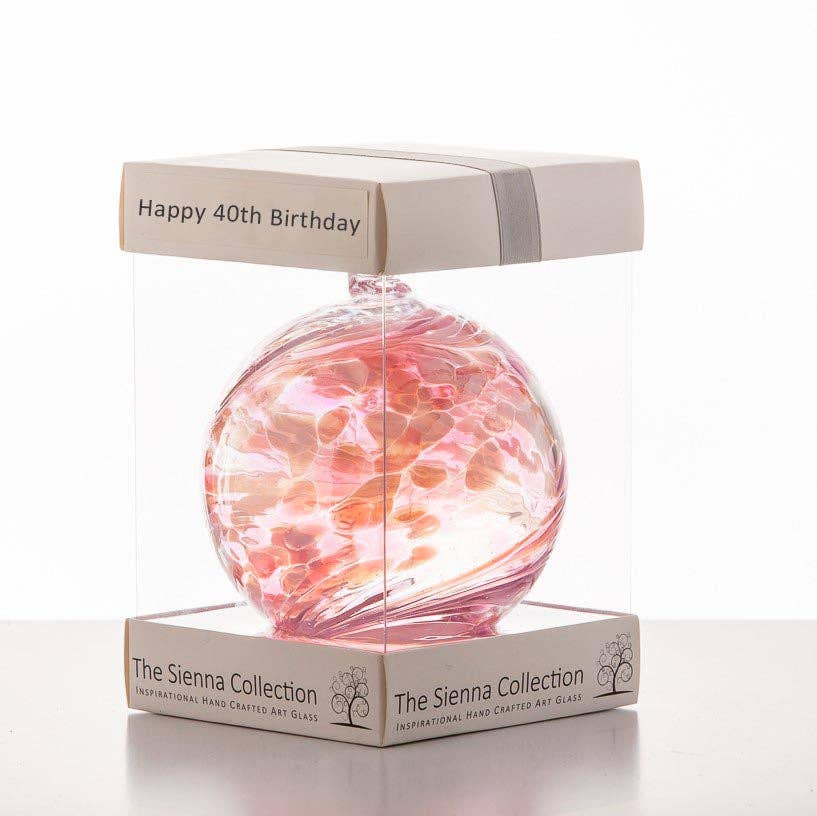 Pink and white glass friendship ball in clear gift box labeled Happy 40th Birthday