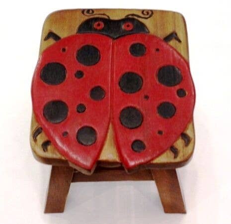 Small wooden stool with a red and black ladybug design on top